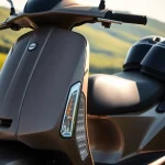 motorroller 50ccm auf einer malerischen Landstraße mit grünem Hintergrund.