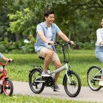 Happy family cycling on colorful tricycles in a sunny park